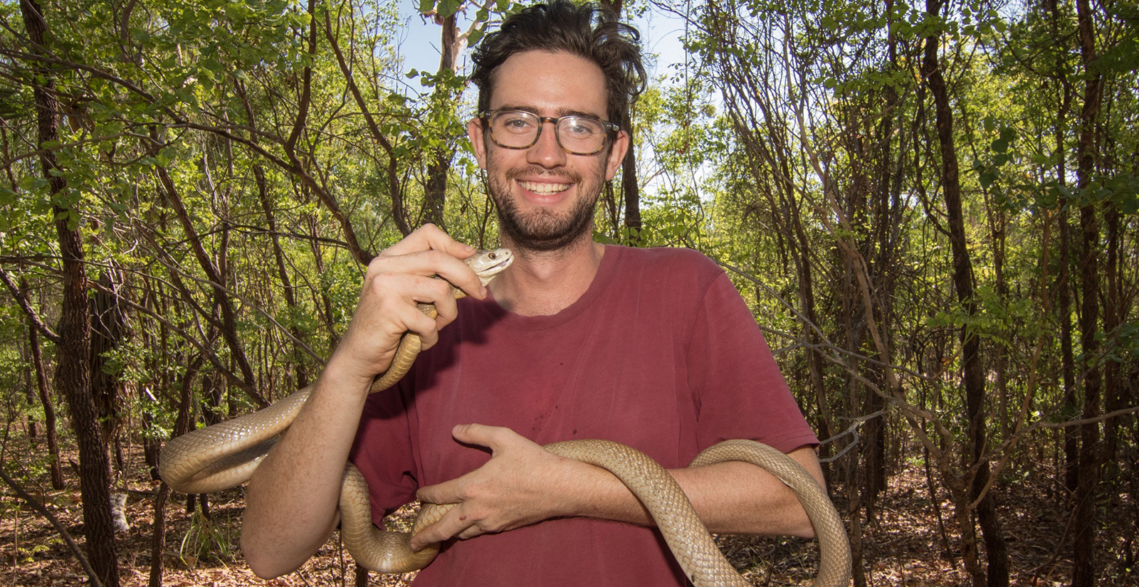 Dr Chris Jolly holding a snake. 
