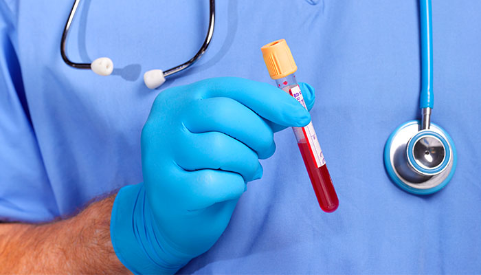 A doctor holding a vial of blood