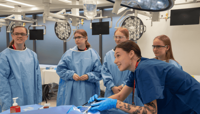 High school students in scrubs at a workshop