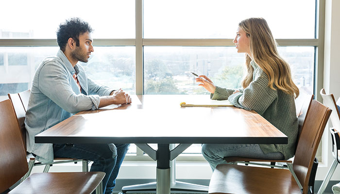 2 people on a desk facing each other