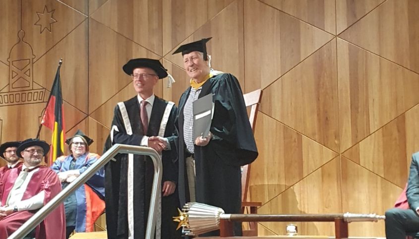 Roger Whalan on stage receiving his graduation certificate