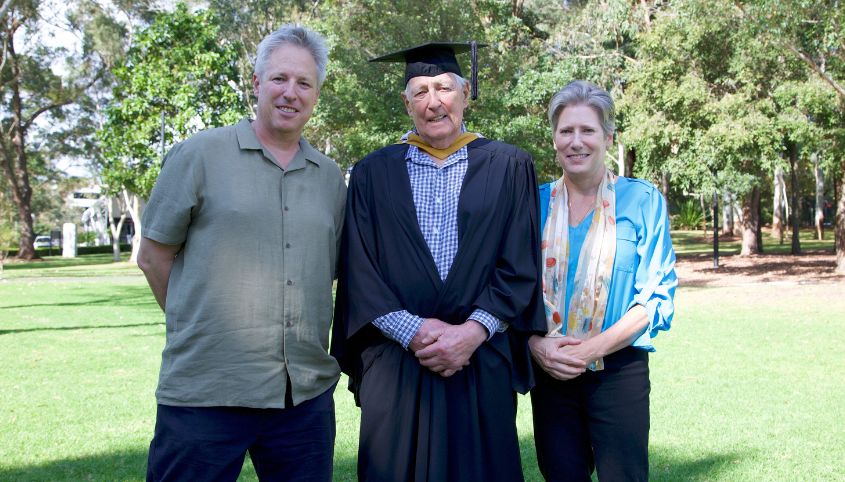 Roger Whalan standing with his two children at his graduation